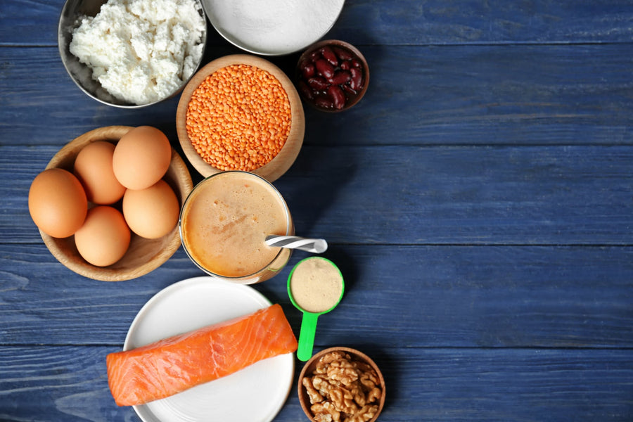 Proteinreiche Lebensmittel wie Skyr, Eier, Linsen und Lachs auf Holztisch als Eiweißquellen beim Abnehmen