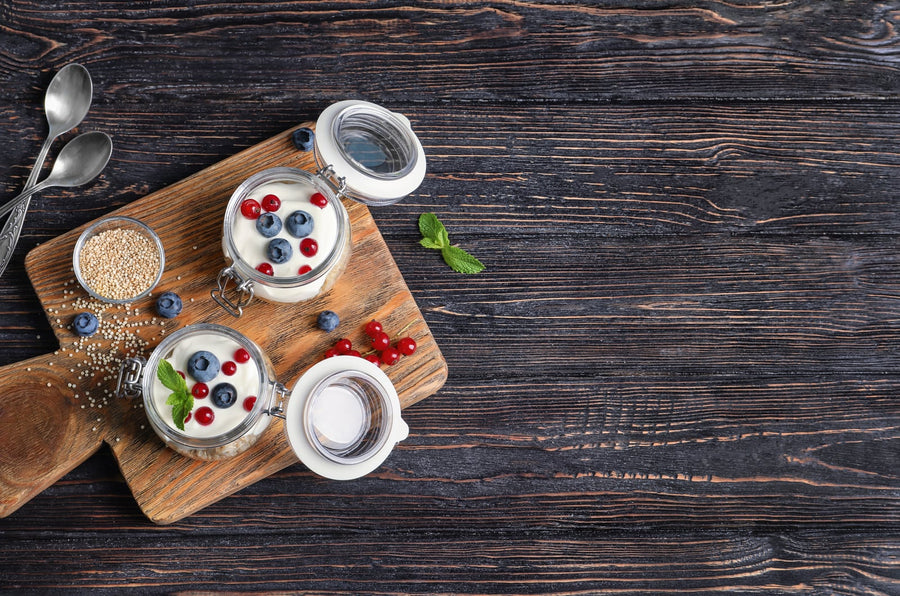 Skyr, Quark und Joghurt in kleinen Schälchen auf hellem Holztisch, Tageslicht