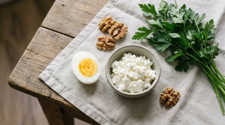 Proteinreiche Lebensmittel – Ei, Hüttenkäse, Walnüsse – auf Leinentuch, Draufsicht